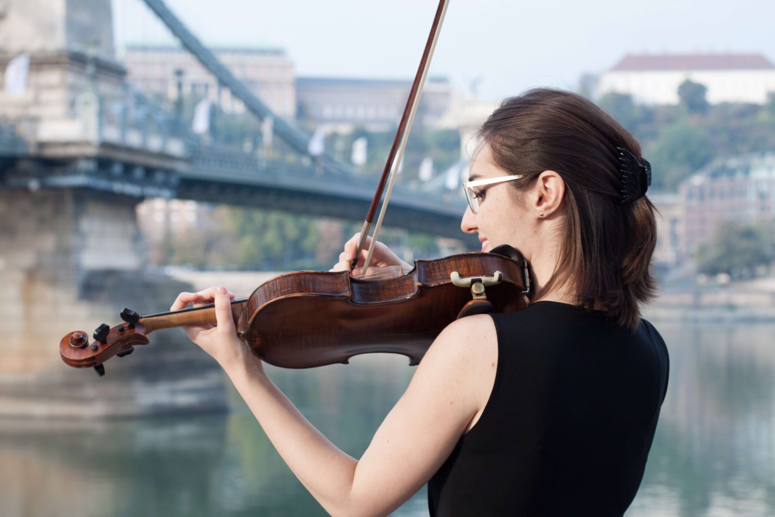 外でバイオリンを弾く女性の画像