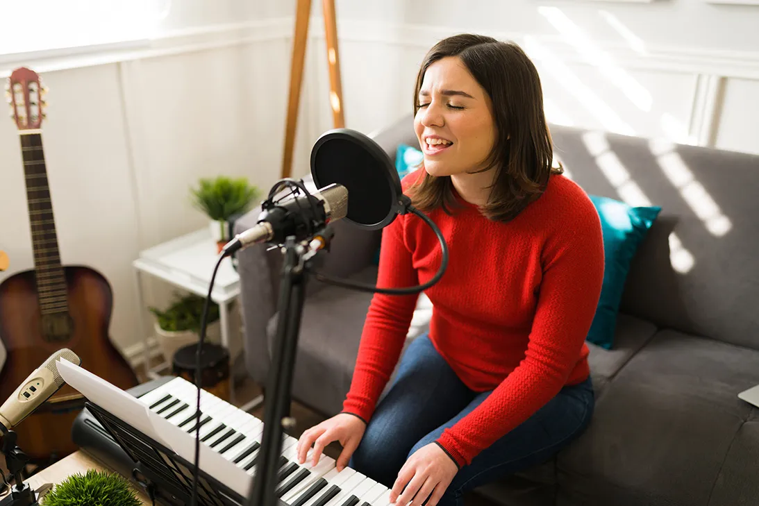 キーボードで弾き語りをする女性