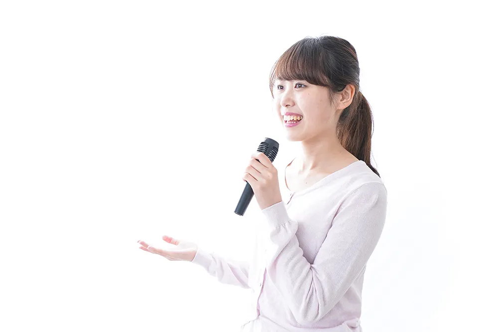 マイクを持って歌う女性