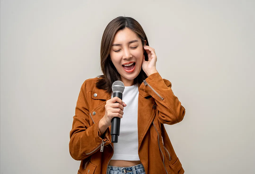 マイクを持って歌う女性・ボイトレ
