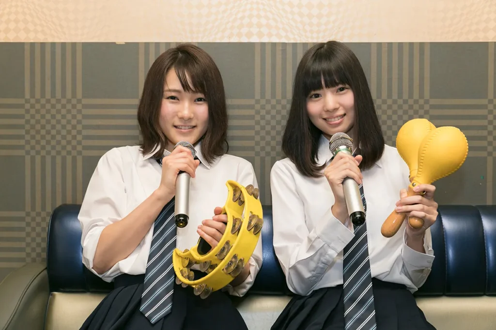 二人の女子高校生がカラオケを楽しむ